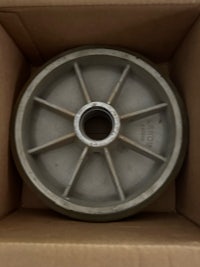 a metal wheel in a cardboard box