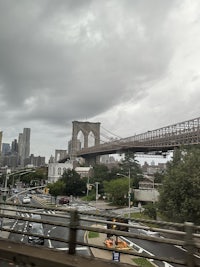 a view of the brooklyn bridge under a cloudy sky