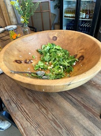 a wooden bowl filled with food on a table