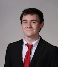 a young man in a black suit and red tie