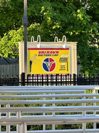 a group of people sitting on a bench in front of a sign