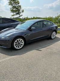 a tesla model 3 parked in a parking lot